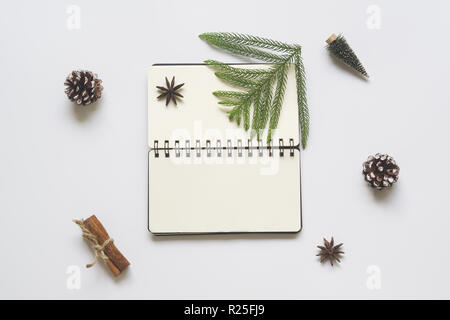 Minimal winter flat lay concept with Christmas ornaments and blank space open note book for your text. Top view with copy space. Stock Photo