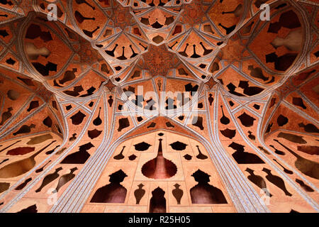 ESFAHAN, IRAN - 26 OCTOBER 2018: Patterned ceiling contrasts with shapes of music instruments in Ali Qapu Palace, situated at Naqsh e Jahan Square Stock Photo