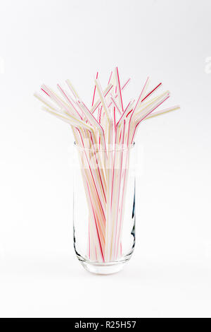 Red stripped straws in glass on white table Stock Photo