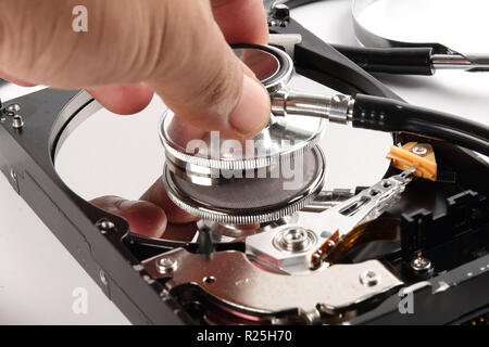 RECOVERY AND REPAIR TECHNOLOGY CONCEPT: Hard Disk Drive (HDD) with stethoscope isolated on white. Stock Photo