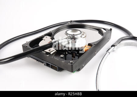 RECOVERY AND REPAIR TECHNOLOGY CONCEPT: Hard Disk Drive (HDD) with stethoscope isolated on white. Stock Photo