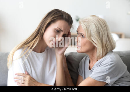 Loving worried older mother comforting supporting sad adult youn Stock Photo