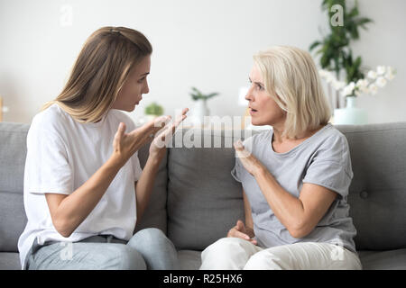 Angry young woman having disagreement with annoyed old mother Stock Photo