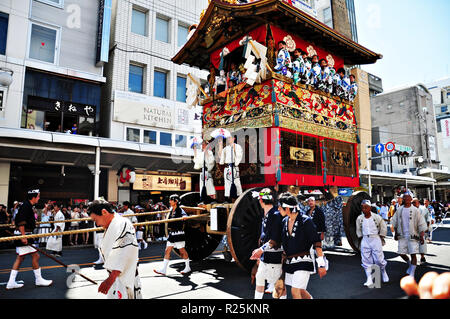 KYOTO, JAPAN: A highly decorated float along with its accompanying men in traditional Japanese clothes is being dragged in a parade during the Gion Ma Stock Photo