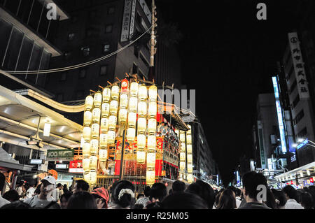 KYOTO, JAPAN - JULY 15, 2011: A portable shrine covered in red and gold embroidered cloth and attached to glowing paper lanterns