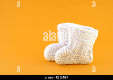 Pair of small baby socks on orange background Stock Photo