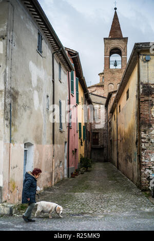 Old woman and her dog in the street of the Urbania, Italy, Europe. Stock Photo