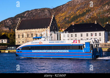 High speed passenger catamaran Rygerfonn departing from the port of Bergen, Norway. In background, Haakons Hall and Bergenhus fortress Stock Photo