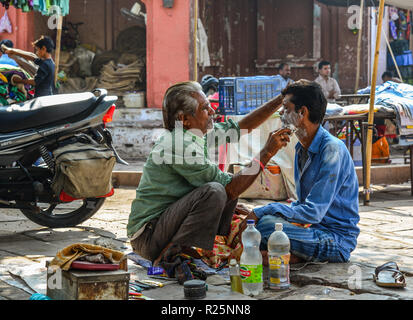 Jodhpur, India - Nov 6, 2017. A man gets a shave at a street barber shop in Jodhpur, India. Jodhpur is the second largest city in state of Rajasthan. Stock Photo