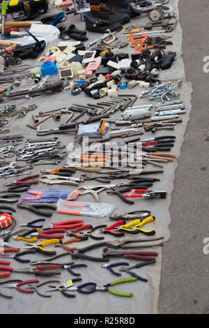 Old metal wrench, key, pliers lying on the asphalts at flea market in Kiev, Ukraine Stock Photo
