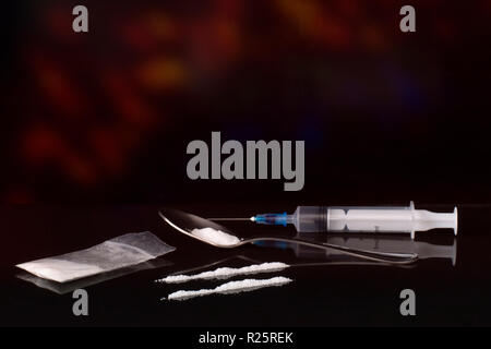 Drug abuse, addiction concept. Lines of white powder, syringe and spoon with party style background. Social issue. Stock Photo