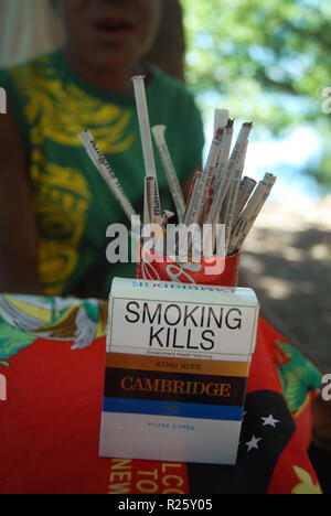 Woman selling handmade cigarettes at market in Madang, Papua New Guinea  Stock Photo