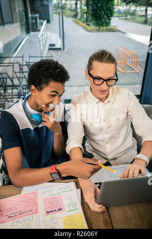 Joyful afro American man pointing at the screen Stock Photo