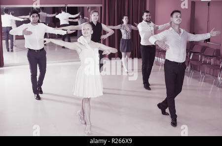 Young people practicing passionate samba in dance class Stock Photo