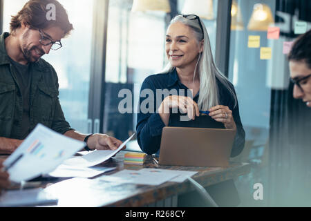 Team of professionals reviewing few finance documents in a meeting. business team analyzing financials documents in a meeting. Stock Photo
