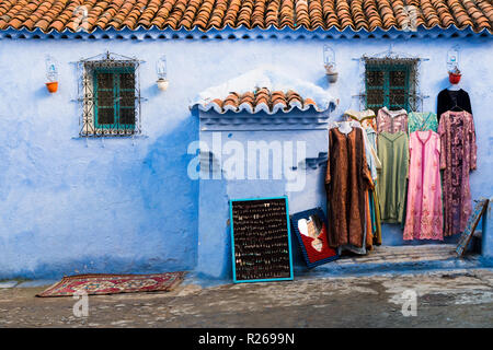 Colorful dresses in small street of Chefchaouen city in Morocco Stock Photo