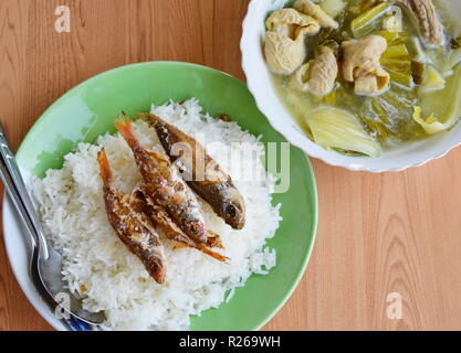 deep fried fish topping on rice and pickled Chinese cabbage with pork entrails soup Stock Photo