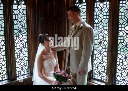 Bride and groom in front of pretty windows after wedding service Stock Photo