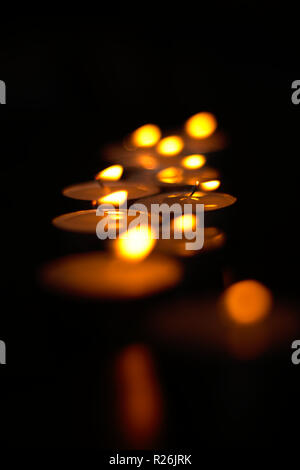 Tealight candles burning in the dark Stock Photo