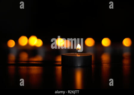 Tealight candles burning in the dark Stock Photo