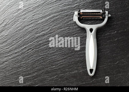 Device for peeling fruits and vegetables, peeler, on a black background, space for text Stock Photo