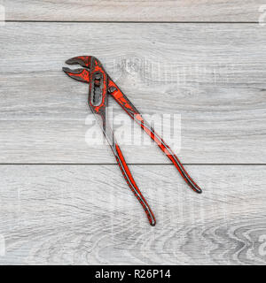 a pipe wrench on a wooden table Stock Photo