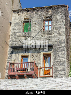 August 2013, Mostar.  A traditional old stone house with balcony terrace in the Old Town. Bullet holes from the war are visible on the wall of the nex Stock Photo