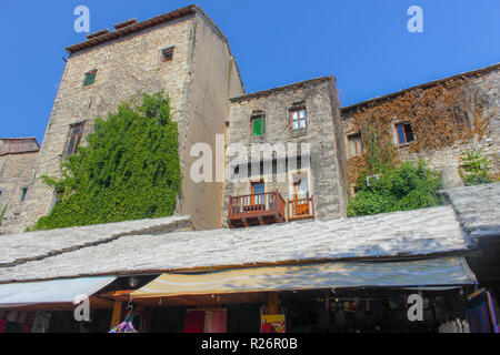 August 2013, Mostar.  Traditional old stone buildings with balcony terrace in the Old Town. Bullet holes from the war are visible on the side wall of  Stock Photo