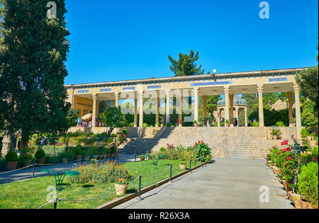 SHIRAZ, IRAN - OCTOBER 13, 2017: The territory of Hafez Mausoleum, located in lush Mussala Gardens with flowers in pots and coniferous trees, on Octob Stock Photo