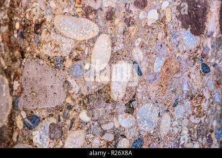 Old and cracked stone wall of some building or pavement Stock Photo