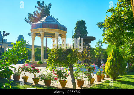 The site of Hafez Tomb is located in beautiful Mussala Gardens with lush trees, trimmed bushes and flowers in pots, Shiraz, Iran. Stock Photo