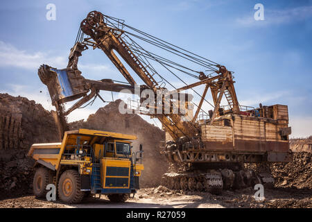 Excavator loading dump truck at coal mining Stock Photo