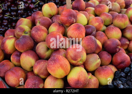 Pile of nectarines. Fresh fruit at grocery shop. Stock Photo