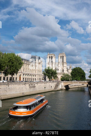 Sightseeing boat moving on river Seine near Notre-Dame de Paris cathedral, Paris, France Stock Photo