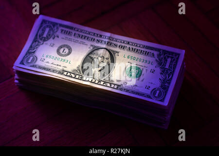 close up American one dollar bills pile on wooden table Stock Photo