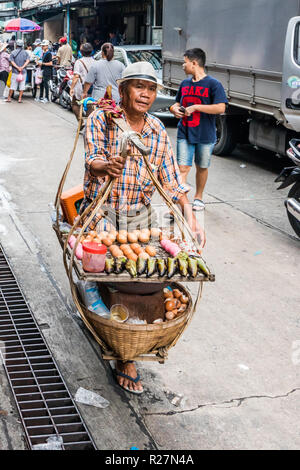 Bangkok, Thailand - 6th October 2018: A street vendor selling eggs walks down the street, There are still many mobile street vendors in the city. Stock Photo