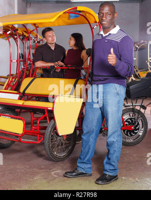 Adult successful African American driver of pedicab offering touristic tour Stock Photo
