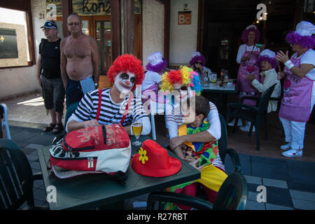 Carnival clown face hair stripes shirt red hair cap smiling face man lady girl boy ladies dressed up mauve hair chefs chef cooking inside faces face Stock Photo