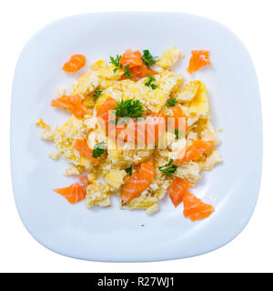 Top view of Norwegian smoked salmon omelette with greens served on white plate on wooden background.  Isolated over white background Stock Photo