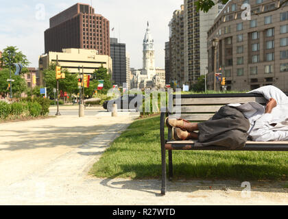 Homeless man sleep on a bench in the center of Philadelphia Stock Photo