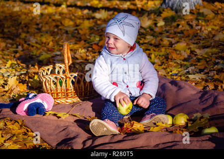 girl in autumn eating an apple sitting on yellow Stock Photo