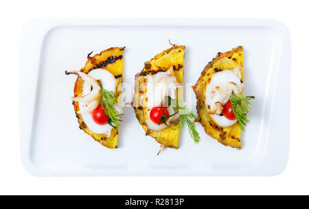 Image of sepia fried on a grill with pineapple, cherry tomatoes and sauce Chile on the plate. Isolated over white background Stock Photo