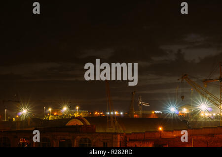 View to old docks and port cranes in night, Senglea, Malta Stock Photo