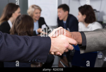 Closeup of businessmen handshake as sign of closing deal on meeting Stock Photo