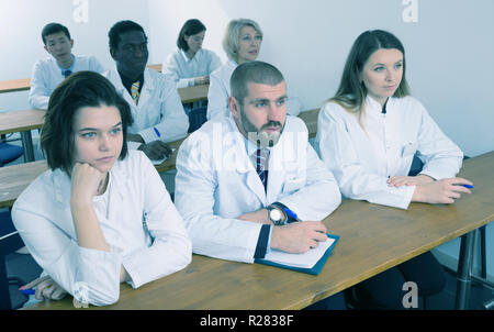 Group of physicians of different nationalities during seminar in conference room Stock Photo