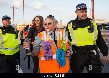 London, UK. 17th November, 2018. Police officers arrest two women, including pensioner Genny Scherer (c), after environmental campaigners from Extinction Rebellion blocked Blackfriars Bridge, one of five bridges blocked in central London, as part of a Rebellion Day event to highlight 'criminal inaction in the face of climate change catastrophe and ecological collapse' by the UK Government as part of a programme of civil disobedience during which scores of campaigners have been arrested. Credit: Mark Kerrison/Alamy Live News Stock Photo