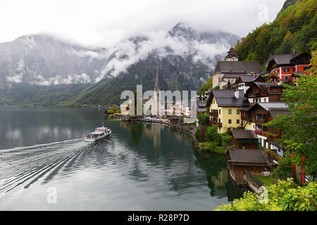 Scenic picture-postcard view of famous Hallstatt lakeside town in the Austrian Alps with passenger ship in beautiful morning light at sunrise on a sun Stock Photo