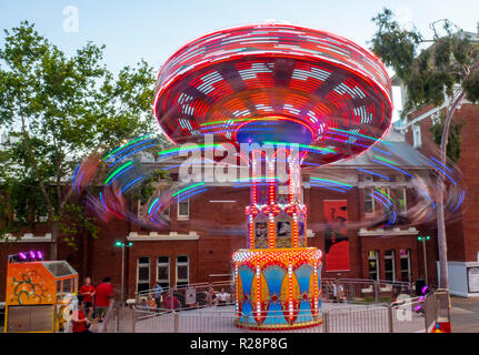People riding a swing carousel ride Christmas festival Perth Cultural Centre Perth Western Australia. Stock Photo