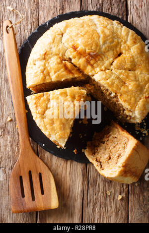 Snack rustic tourtiere pie with pork, mashed potatoes and spices close-up on the table. Vertical top view from above Stock Photo