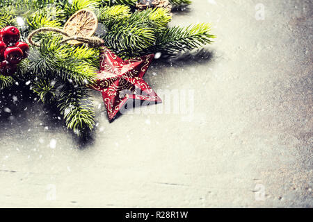 Christmas star spruce branches and cones on dark board. Stock Photo